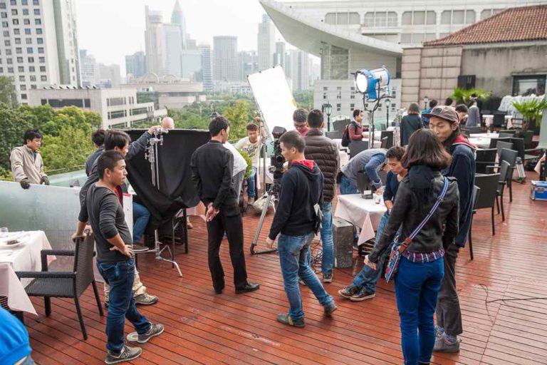 China production team preparing lighting and camera support for a shoot